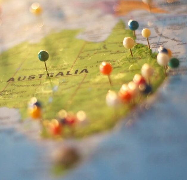 Close-up of a map of Australia with colorful pins marking various cities and destinations.