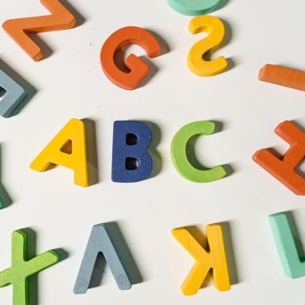 Bright, colorful wooden alphabet letters scattered on a surface ideal for children's learning.